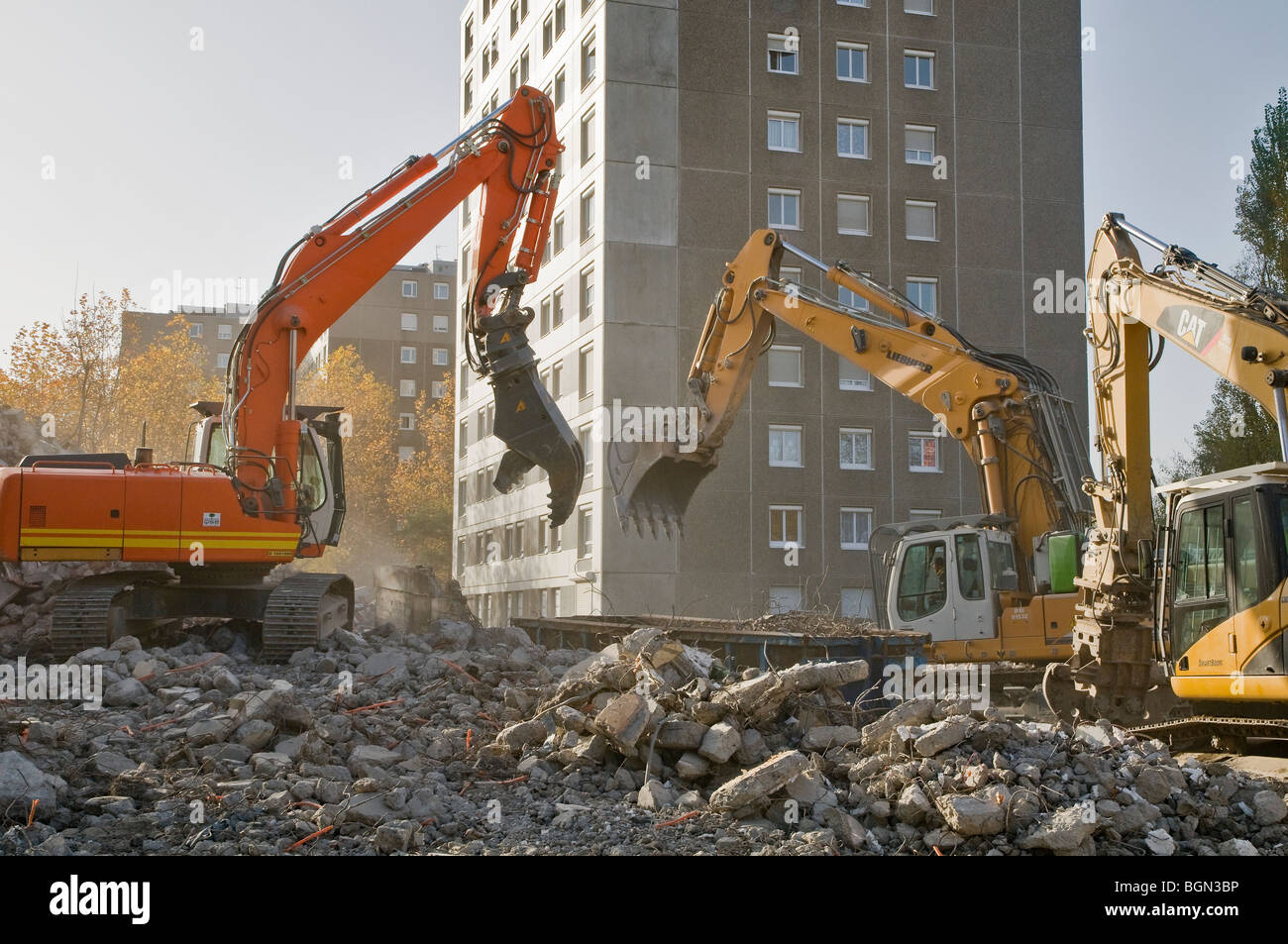 Tre escavatori in azione su un edificio sito di demolizione di HLM edificio, Francia Foto Stock