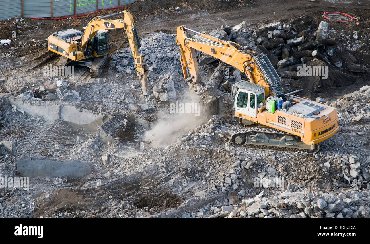 Escavatori cingolati su un edificio cantiere di demolizione Foto Stock