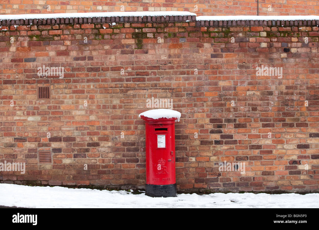 Un tradizionale pilastro rosso box coperto di neve a Worcester, Regno Unito Foto Stock