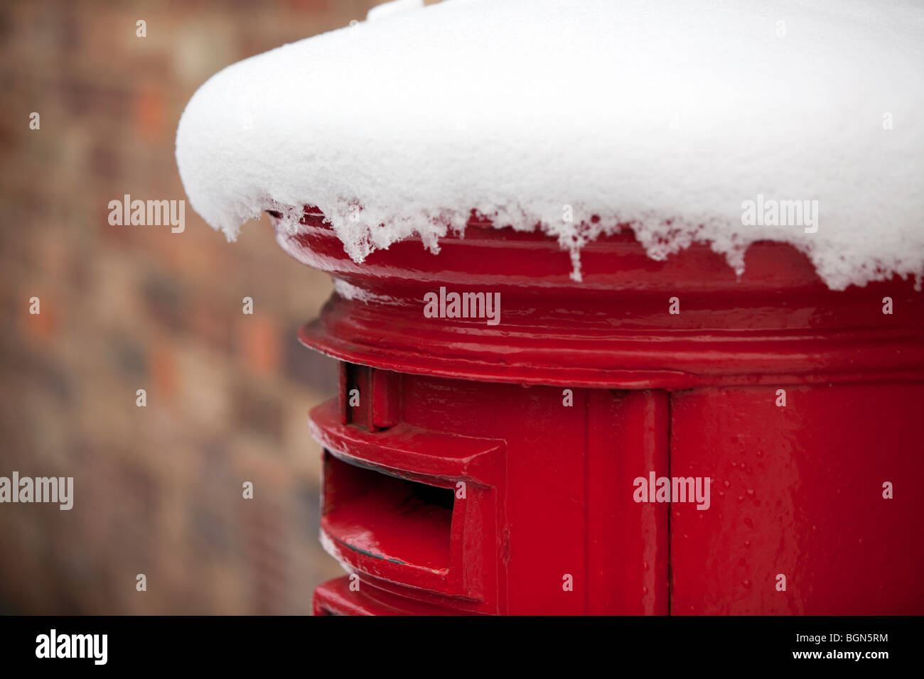 Un tradizionale pilastro rosso box coperto di neve a Worcester, Regno Unito Foto Stock