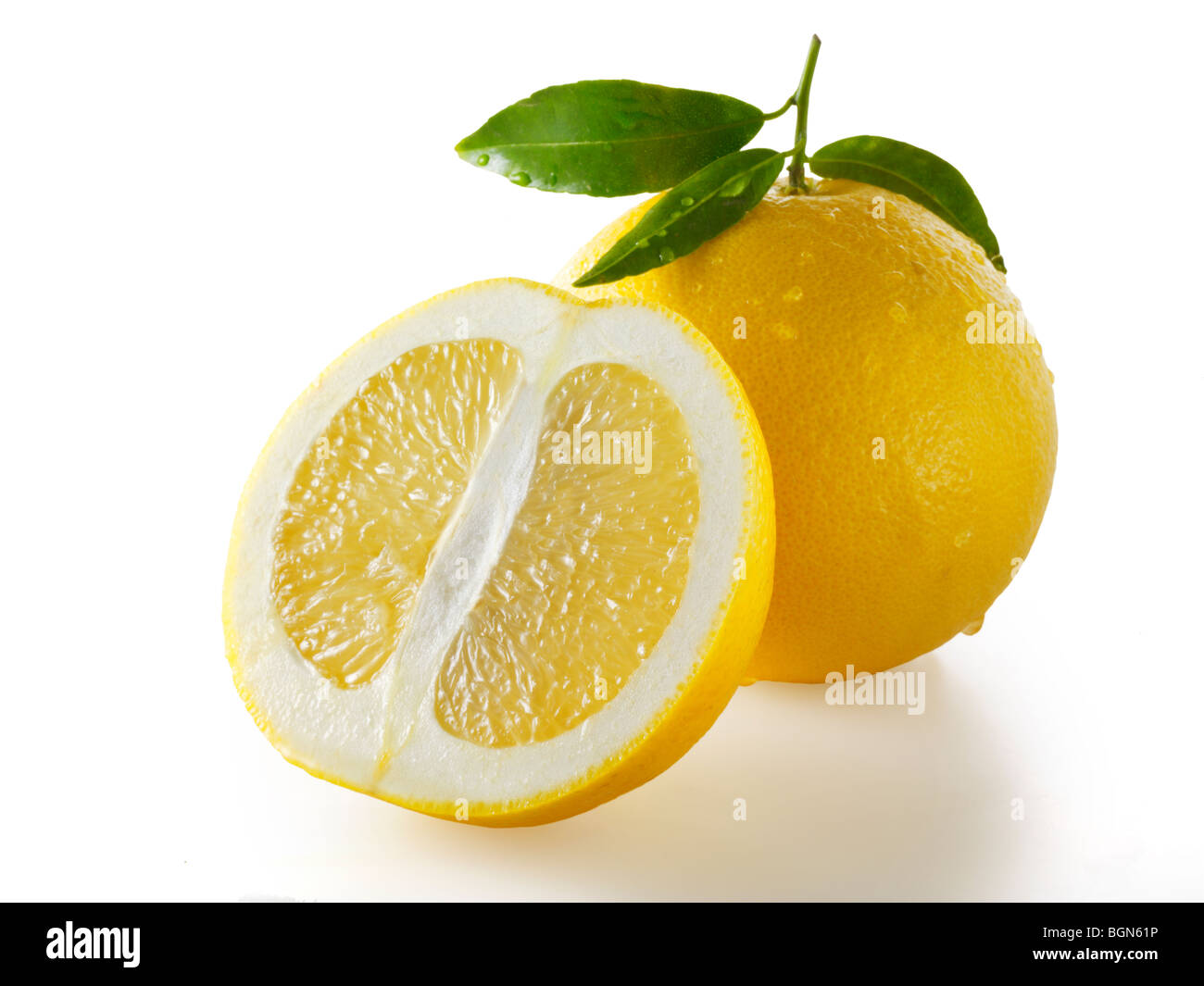 Tutto fresco e tagliare di pompelmo con foglie contro uno sfondo bianco Foto Stock