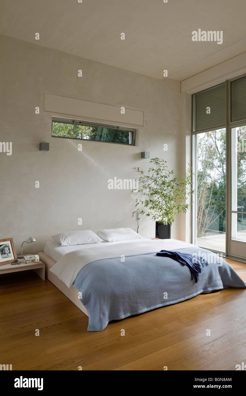 Camera da letto con pavimento in legno in casa contemporanea Foto Stock