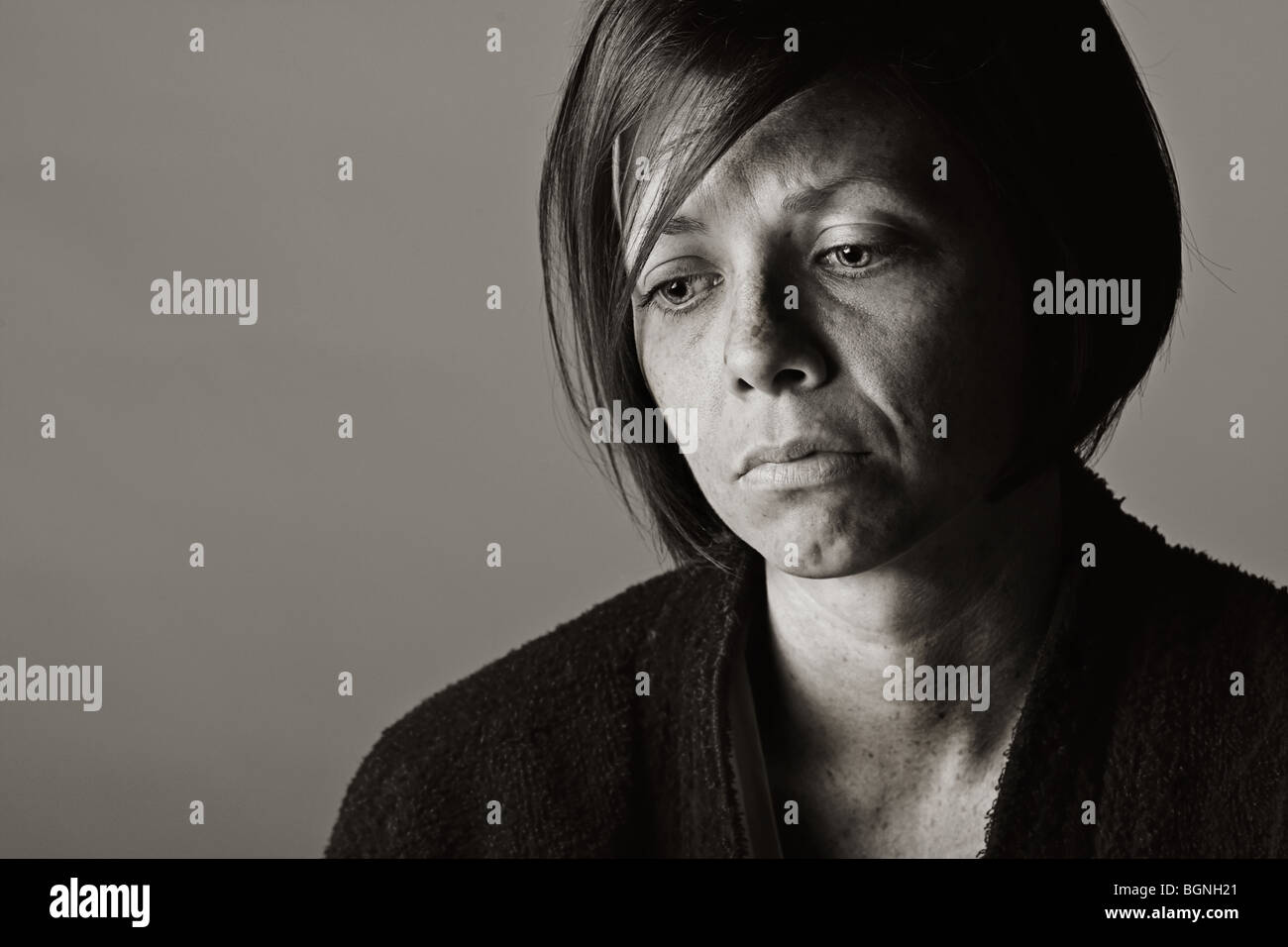Drammatica chiave di basso colpo di un sconvolto 30s signora in vestaglia Foto Stock