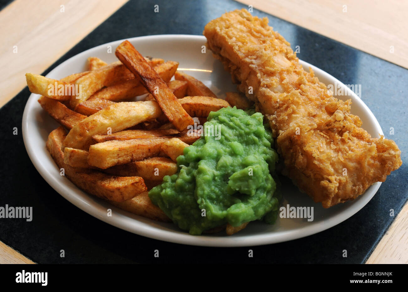 Un piatto di pesce e patatine fiacco piselli Foto Stock