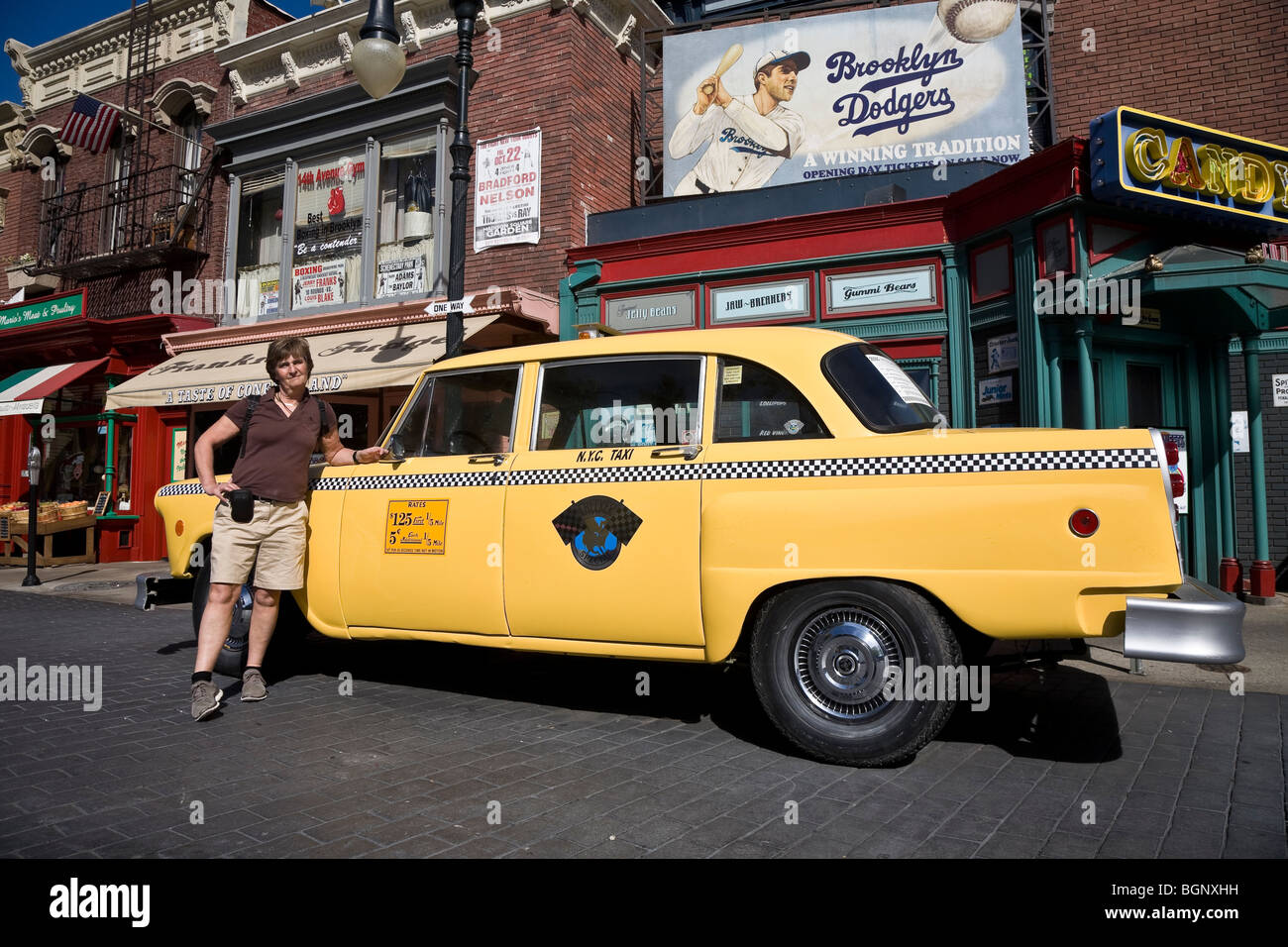 Tourist da un giallo taxi in una Brooklyn street scene, gli Universal Studios Hollywood Los Angeles California USA Foto Stock