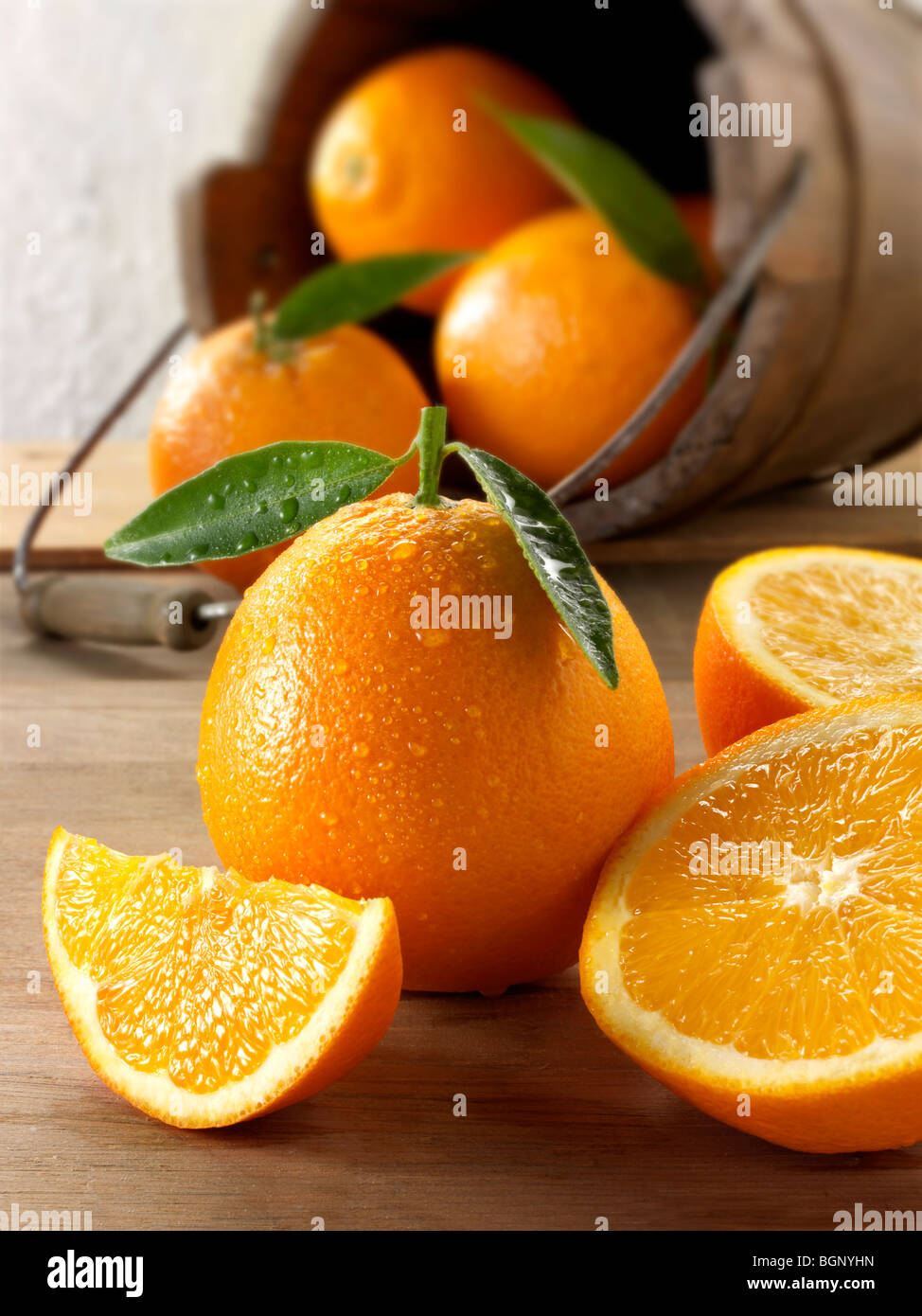 Intero e tagliare le arance fresche in una impostazione di cucina Foto Stock