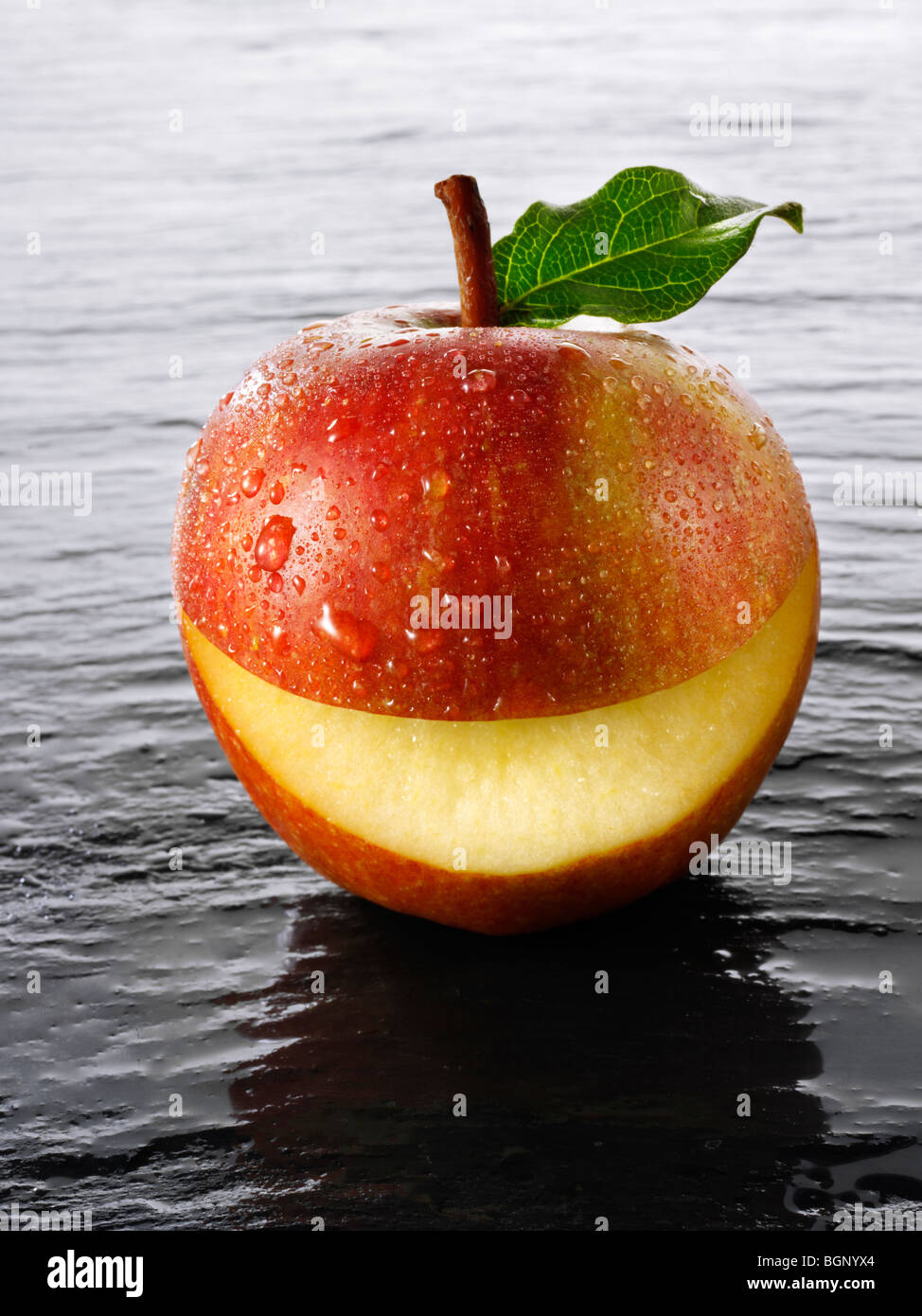 Intero fresco Cox di mele con un sorriso tagliato in essi Foto Stock