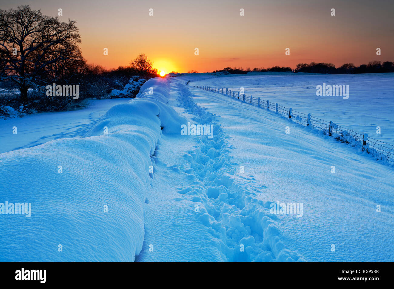 Tramonto invernale sulla neve sul muro romano, Silchester, Hampshire, Regno Unito Foto Stock