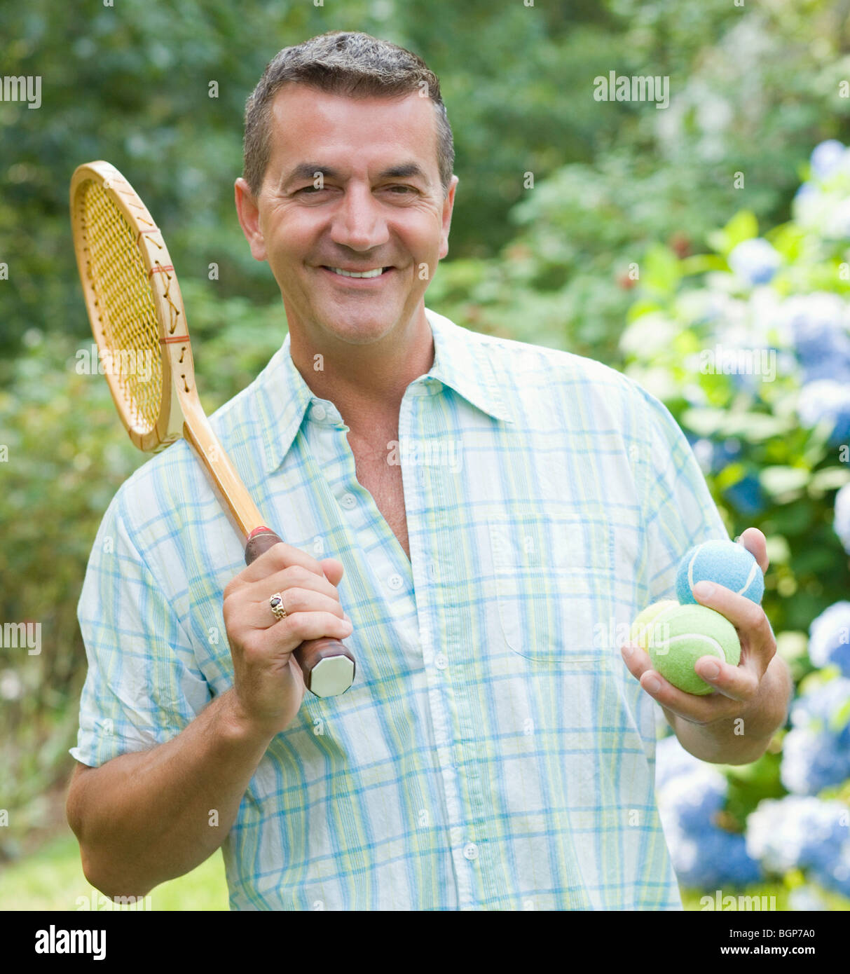 Ritratto di un uomo maturo con una racchetta da tennis e sfere Foto Stock