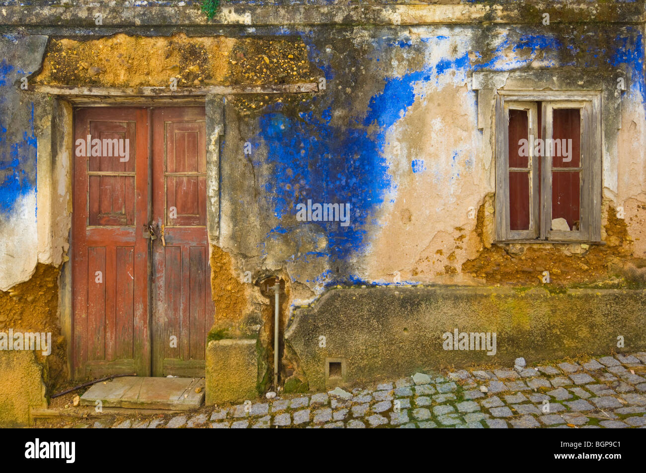 Vecchie pareti e porta di un cottage in rovina dipinta di blu Nel villaggio di AljezurAlgarve distretto Portogallo UE Europa Foto Stock