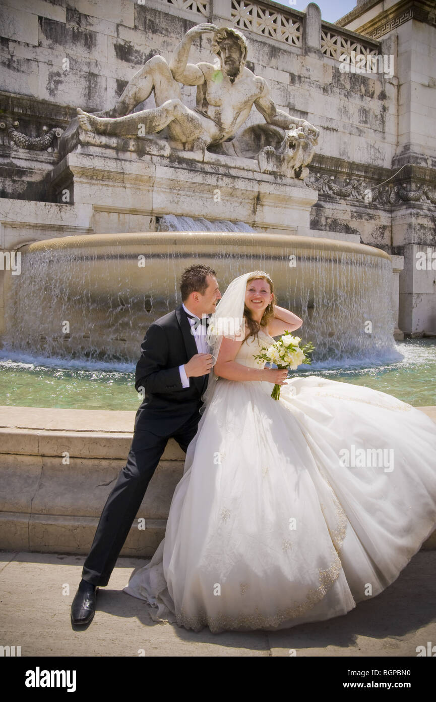 Sposa e lo sposo seduto di fronte a una fontana di acqua Foto Stock