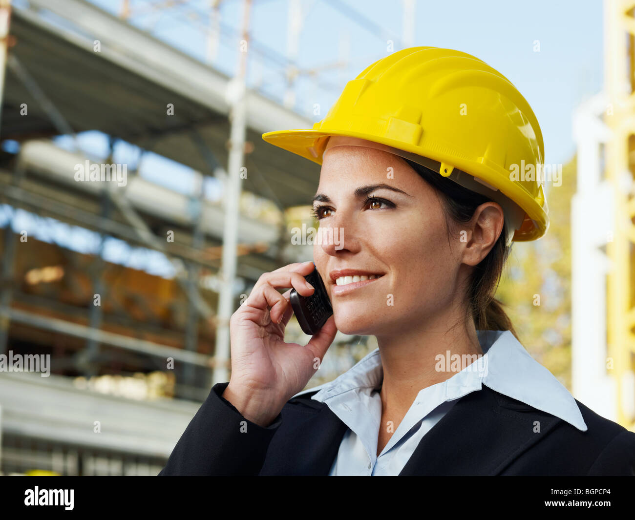 Ingegnere femmina parlando al telefono mobile nel sito in costruzione Foto Stock