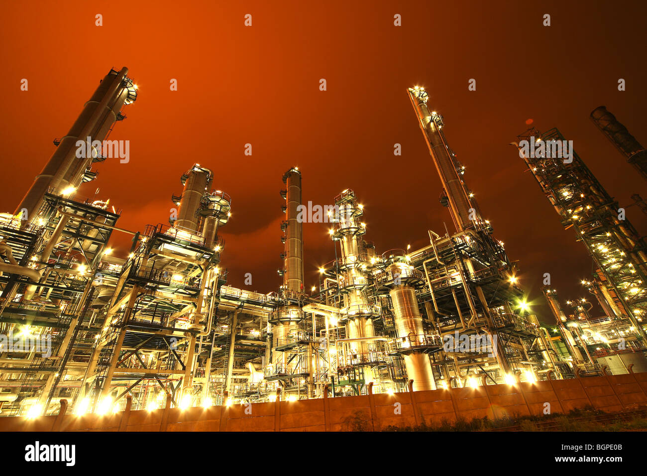 Camini di raffineria di industria petrolchimica illuminata di notte Foto Stock