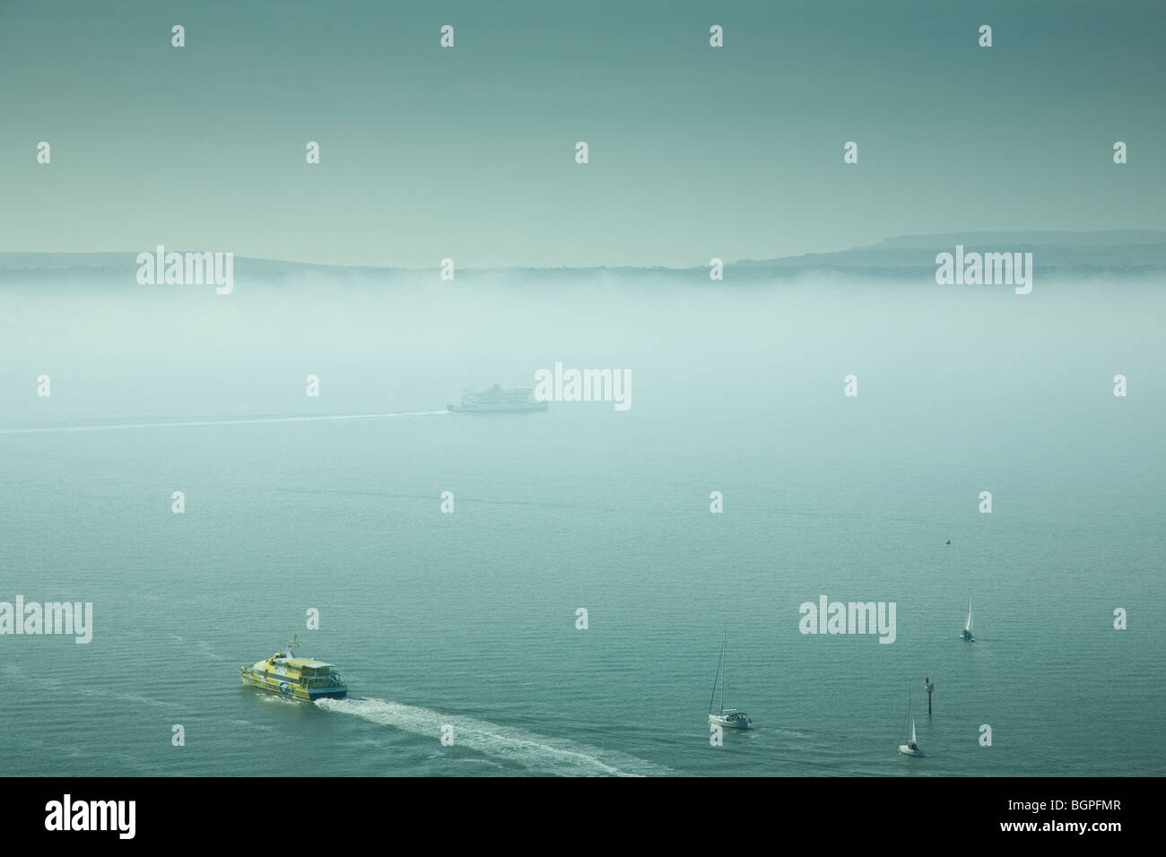 Traghetti e imbarcazioni al di fuori del porto di Portsmouth con la nebbia copriva Isle of Wight in background, da Spinnaker Tower. Foto Stock