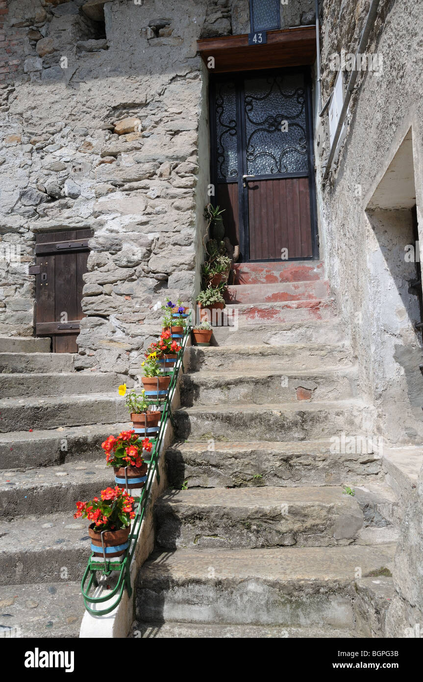 Vecchia scala di pietra decorata con vasi per piante e fiori di casa porta anteriore a Pont Saint Martin Valle d'Aosta Italia Foto Stock