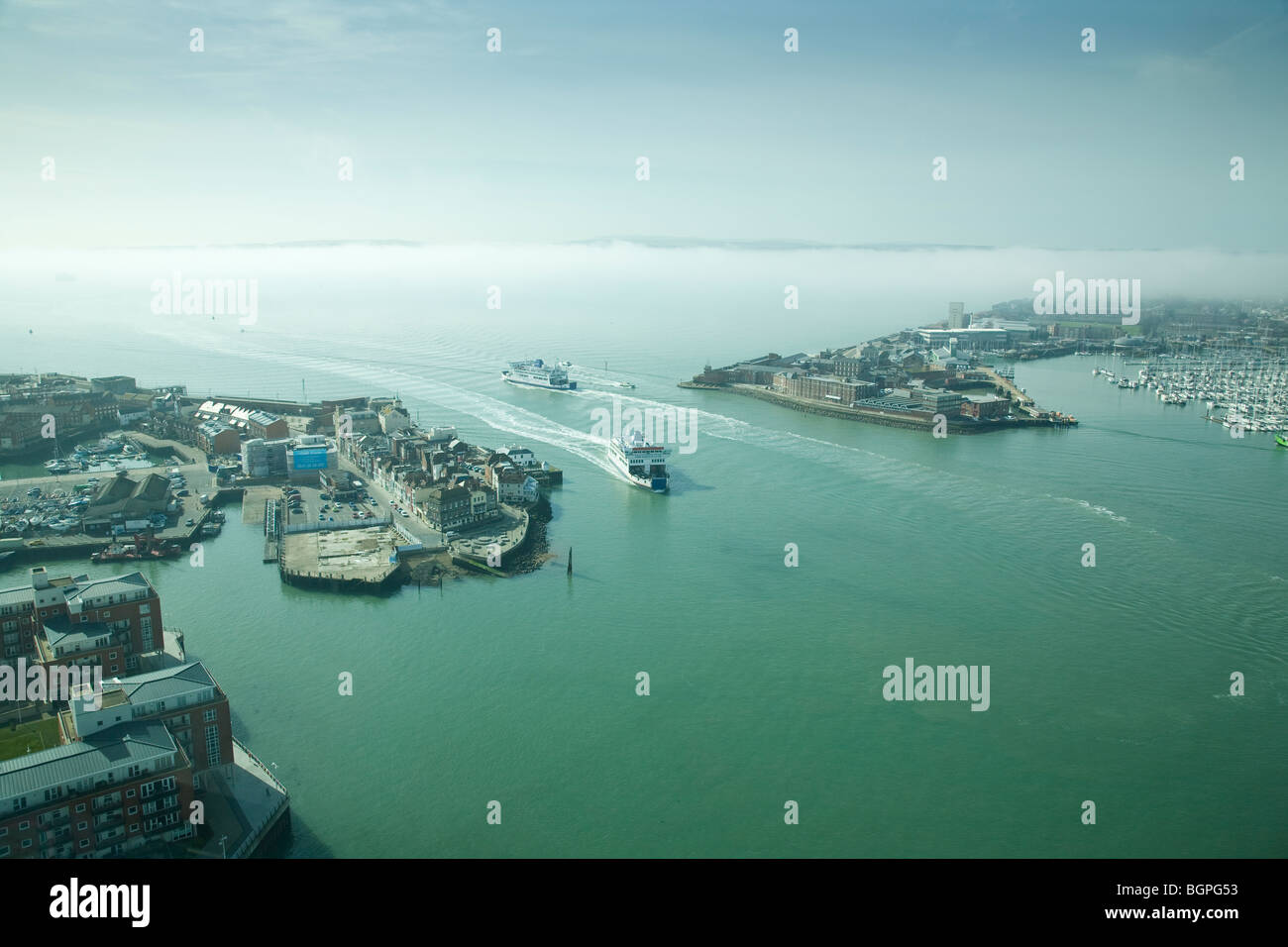 Ferries entra/lasciando il porto di Portsmouth con nebbia copriva Isle of Wight in background, visto da Spinnaker Tower. Foto Stock