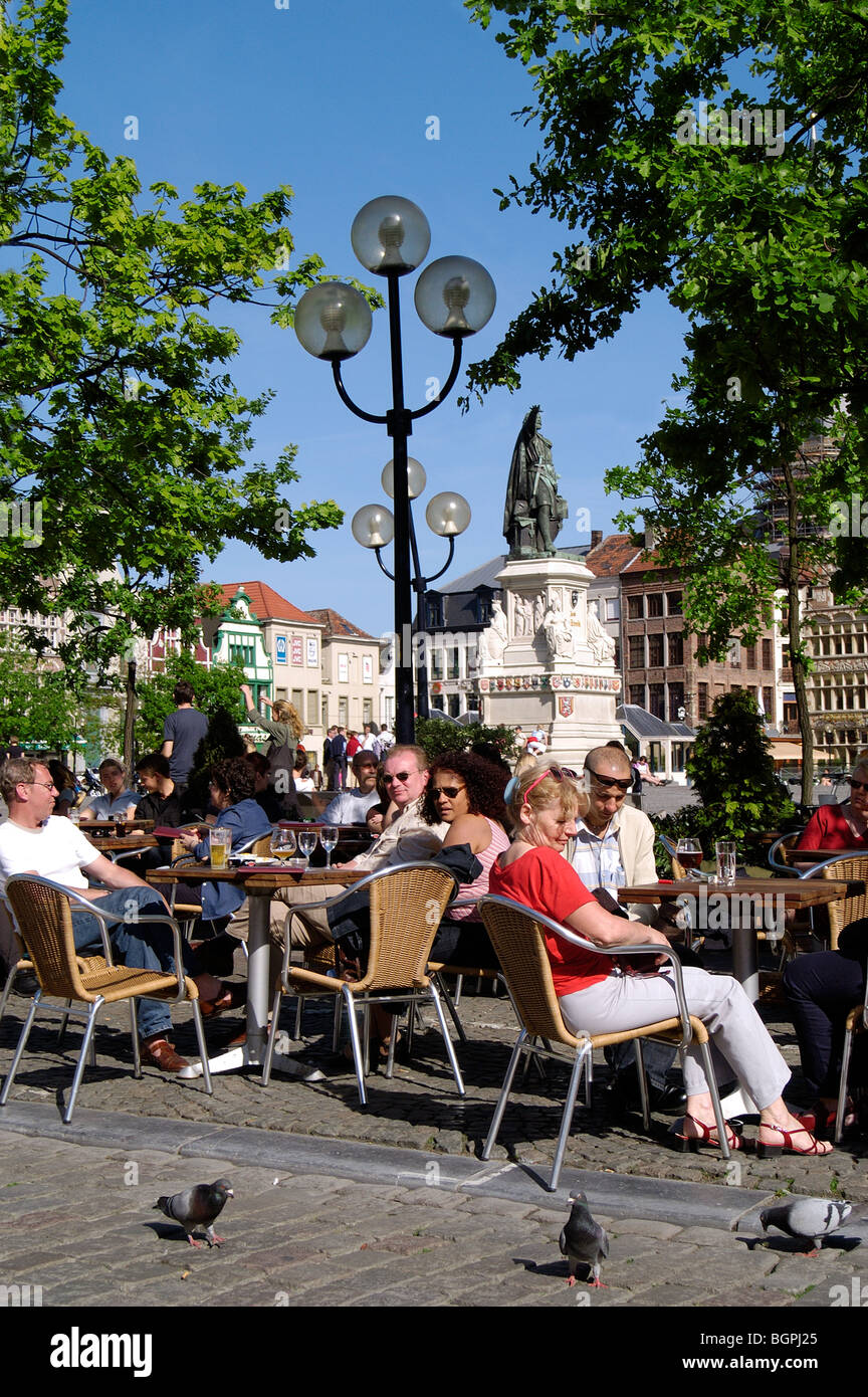 I turisti seduti in una caffetteria sul marciapiede sul mercato del venerdì / Vrijdagmarkt a Gand, Belgio Foto Stock