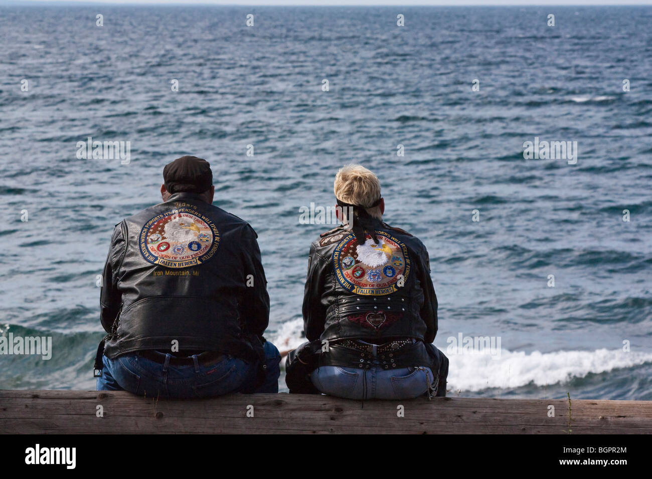 Coppia di motociclisti americani seduti su un lago sulla riva abbigliamento Harley Davidson vestono lo stile di vita degli Stati Uniti da dietro la vista panoramica persone in alta risoluzione degli Stati Uniti Foto Stock