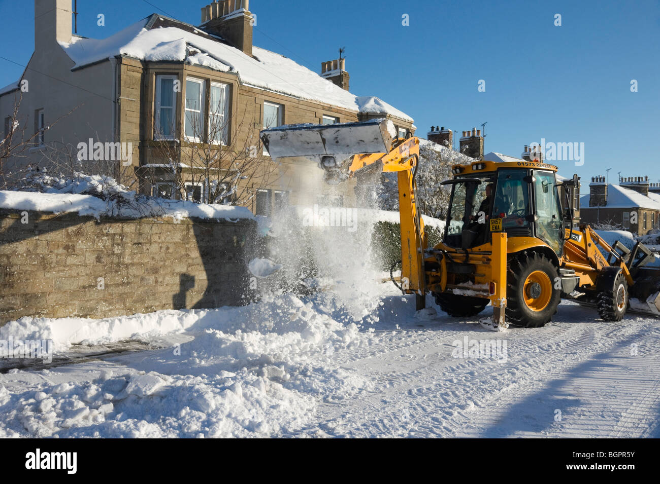 Inverno Gennaio 2010 Scozia - Kelso Scottish Borders. JCB sgombero della neve dalla strada laterale. Foto Stock