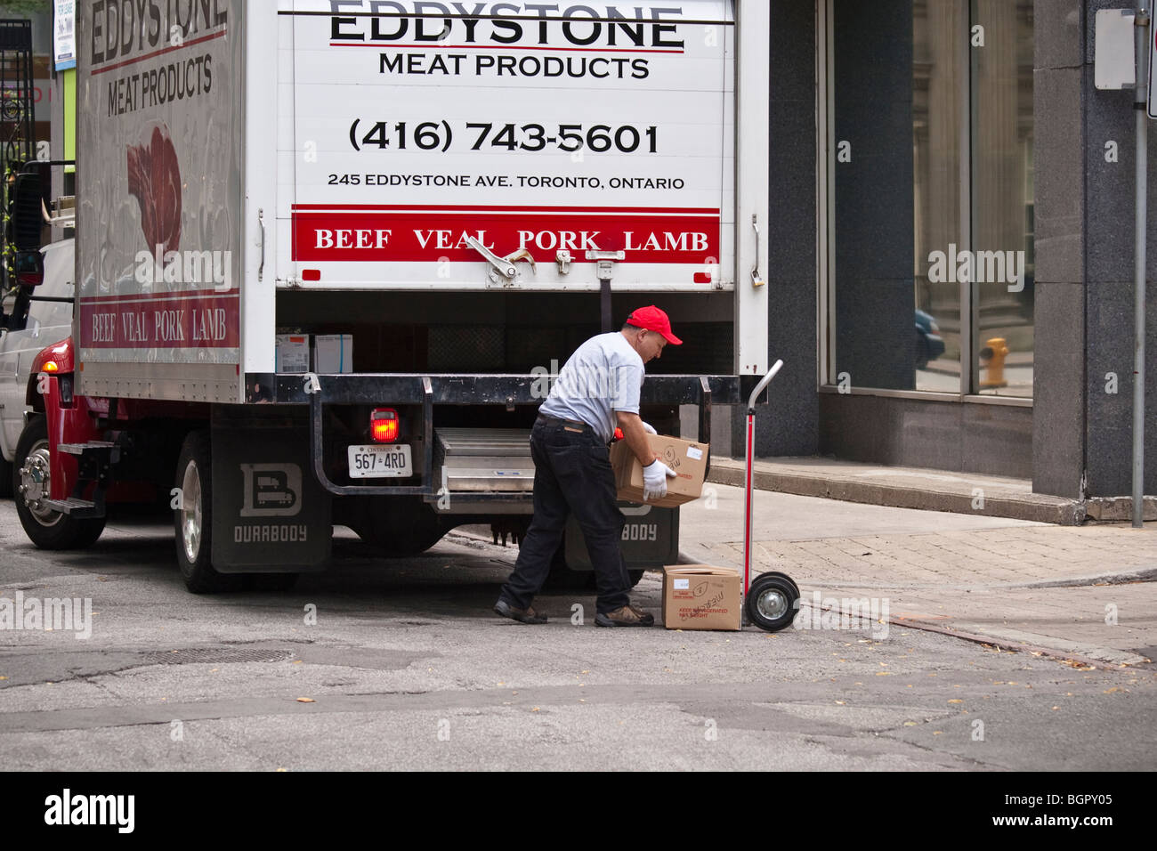 L uomo alla consegna, il caricamento di un carrello con scatole, prodotti a base di carne, Toronto, Canada Foto Stock