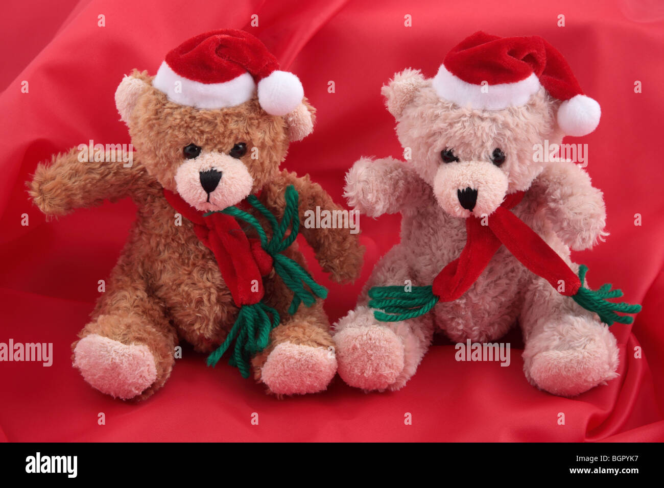 Due orsetti in santa costume contro di raso rosso sfondo Foto Stock