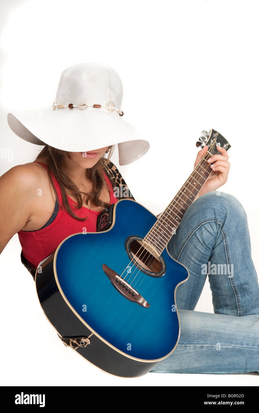Una giovane ragazza sorridente, tenendo una chitarra Foto Stock