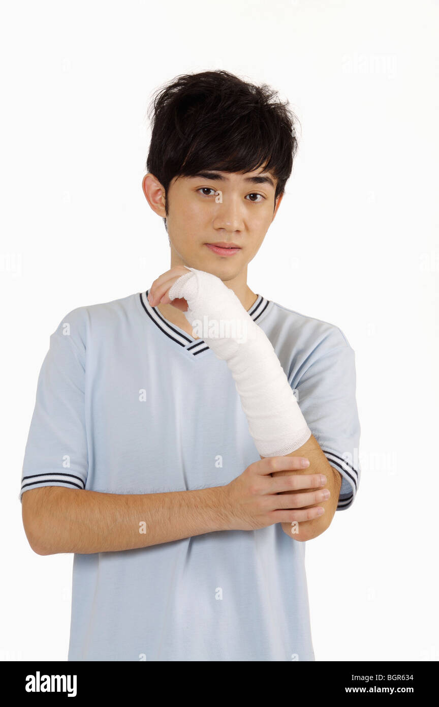 Giovane uomo avente bendaggio adesivo sul braccio rotto Foto Stock