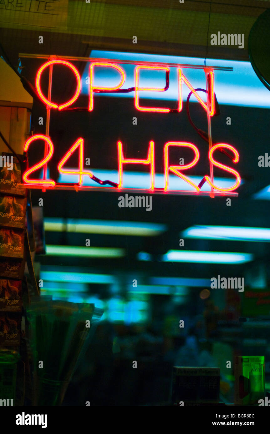 Il Neon 'aperto ventiquattro ore di firmare in una città vetrina di un negozio. Foto Stock