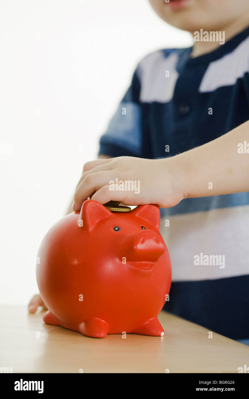 Ragazzino con banche di maiale. Foto Stock