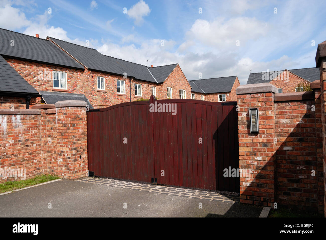 Moderni alloggi rurali station wagon con tastierino azionato cancelli di ingresso. Foto Stock
