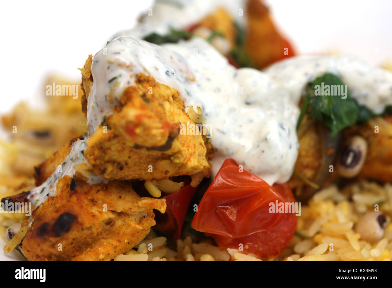 Fresh North Indian Achari Pollo al Curry spiedini con riso pilaf e Raita di cetriolo con nessun popolo contro uno sfondo nero Foto Stock