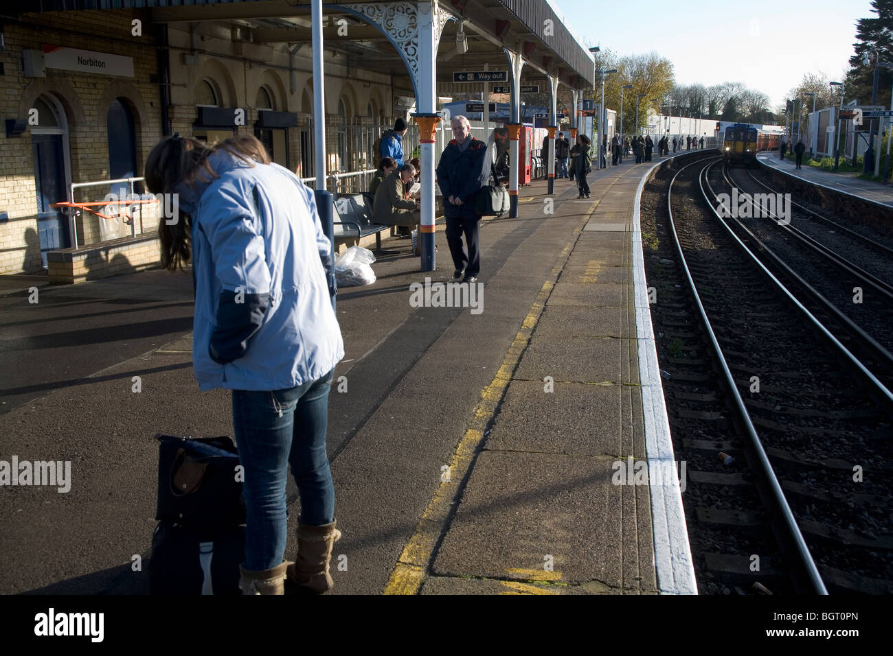 Persone in attesa del treno per arrivare Norbiton Station di Londra, Inghilterra, Regno Unito. Foto Stock