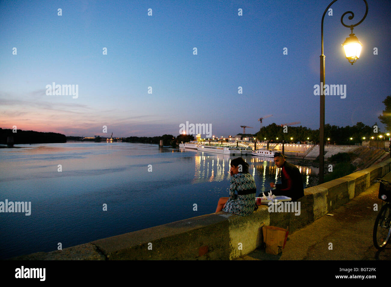 Giovane seduto da Grand Rhone river, Arles, Provenza, Francia. Foto Stock