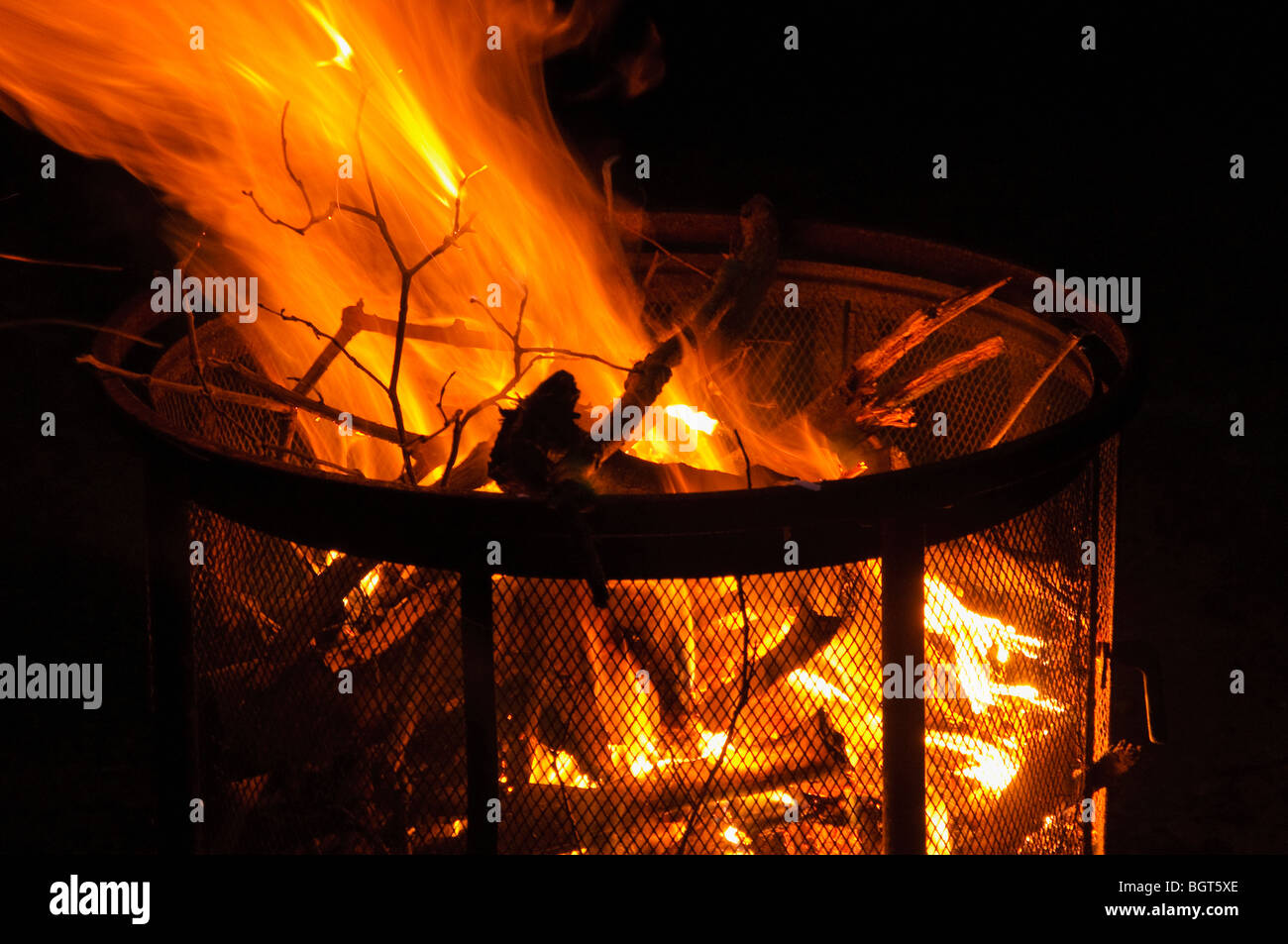 Sera fuoco di campo in un free standing una buca per il fuoco. Foto Stock