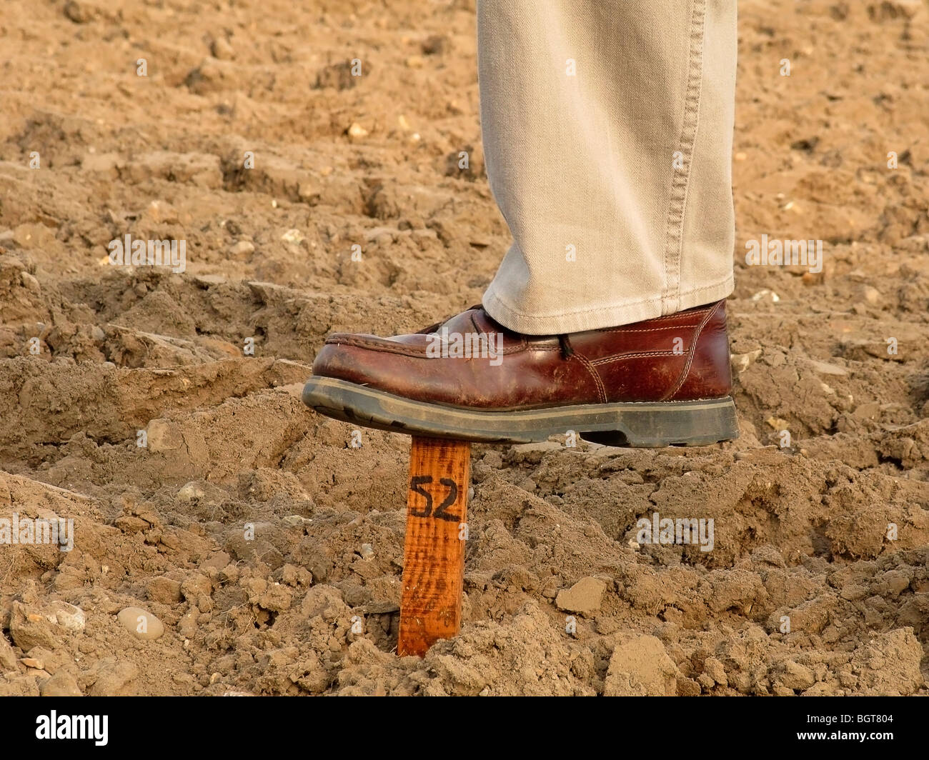 L'uomo con i piedi sul numero stick di riparto grafico Foto Stock