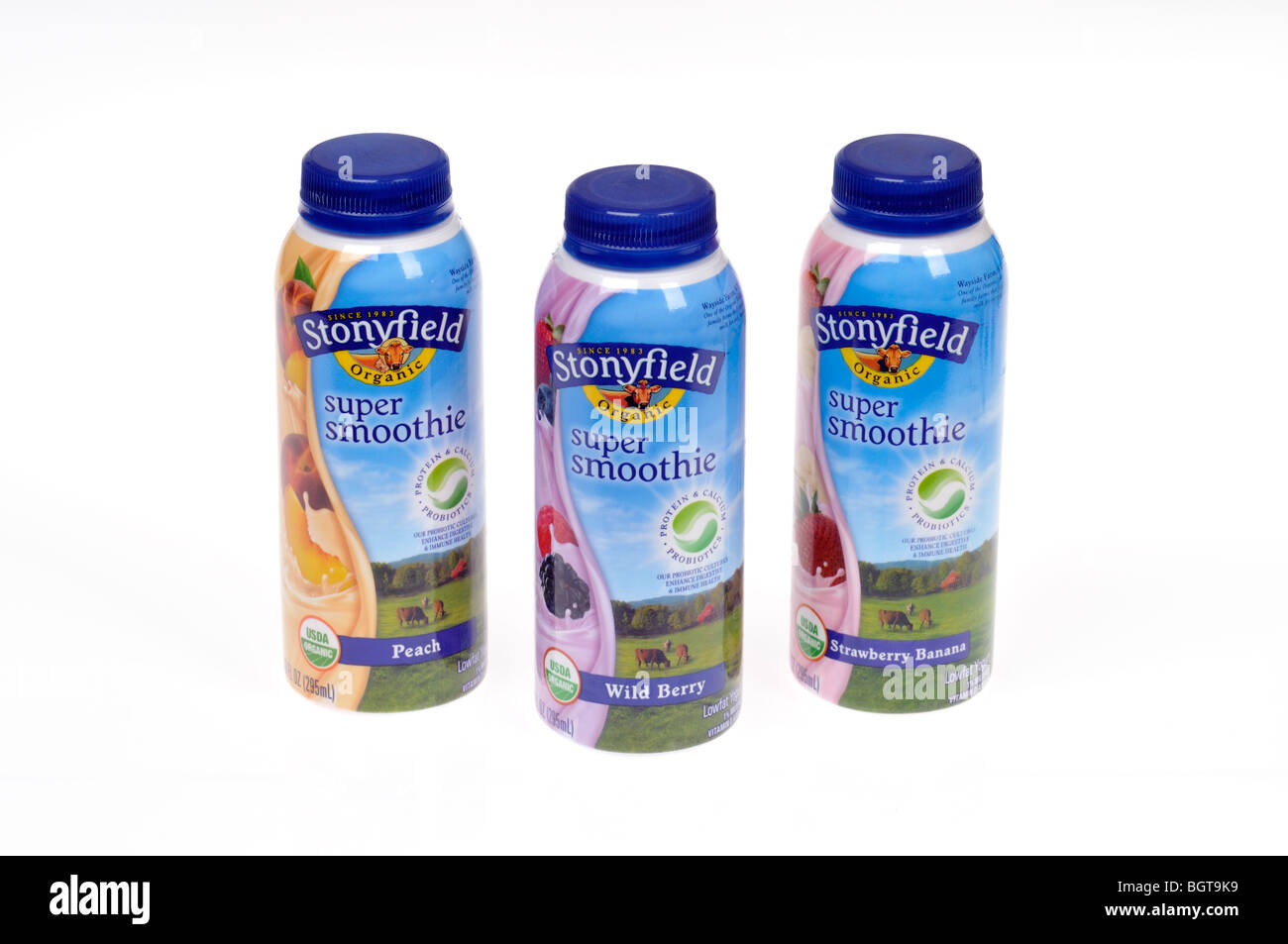 Pesca, frutti di bosco e fragola banana preparata Stonyfield frullati in bottiglie su sfondo bianco, tagliato fuori. Foto Stock