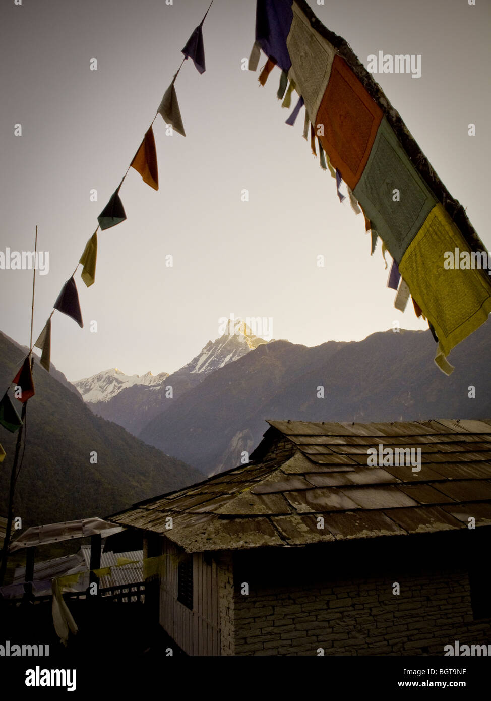 Bandiere di preghiera una casa in Chomrong, regione di Annapurna, Nepal. Foto scattata durante il trekking di Annapurna Base Camp. Foto Stock