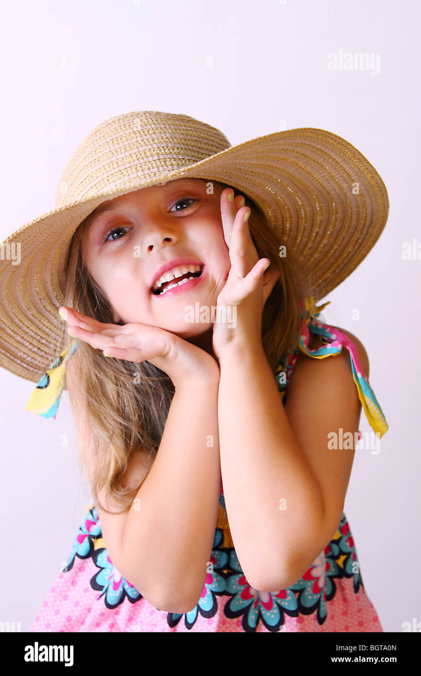 Un felice bimba bionda che indossa un cappello di paglia, utilizza il suo  viso e mani per illustrare l'emozione Foto stock - Alamy