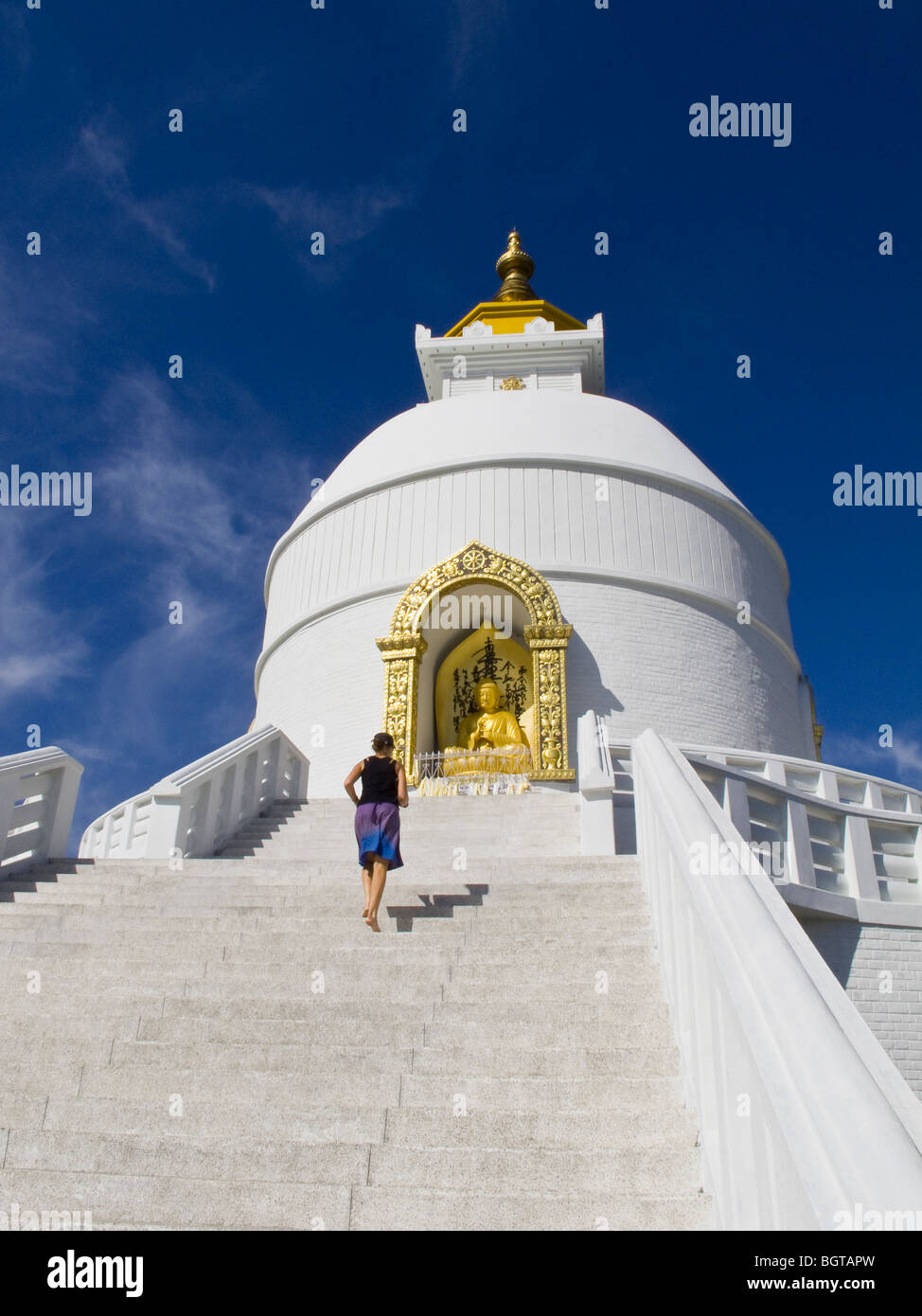 Una donna salendo i passaggi alla Pace Mondiale Pagoda vicino a Pokhara, Nepal. Foto Stock