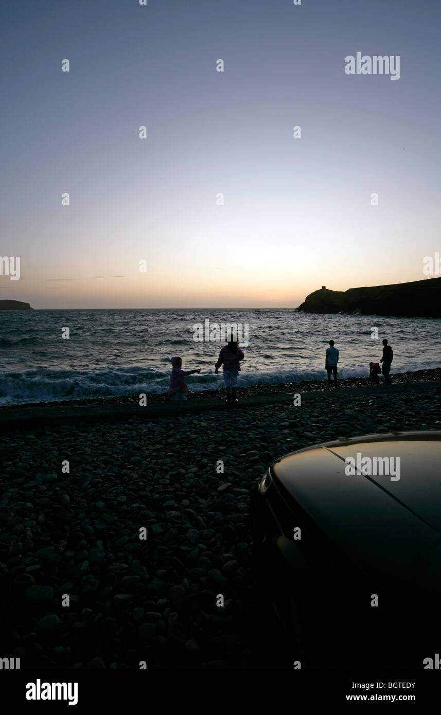 Famiglia di guardare il tramonto o l'alba al mare Foto Stock