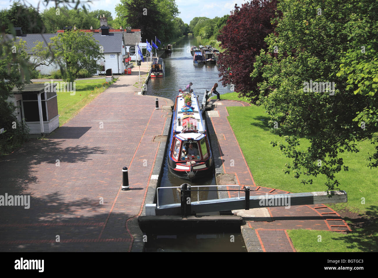 Un charter hotel narrowboat inserendo il blocco di arresto alla giunzione Autherley sul Shropshire Union Canal, England Regno Unito Foto Stock