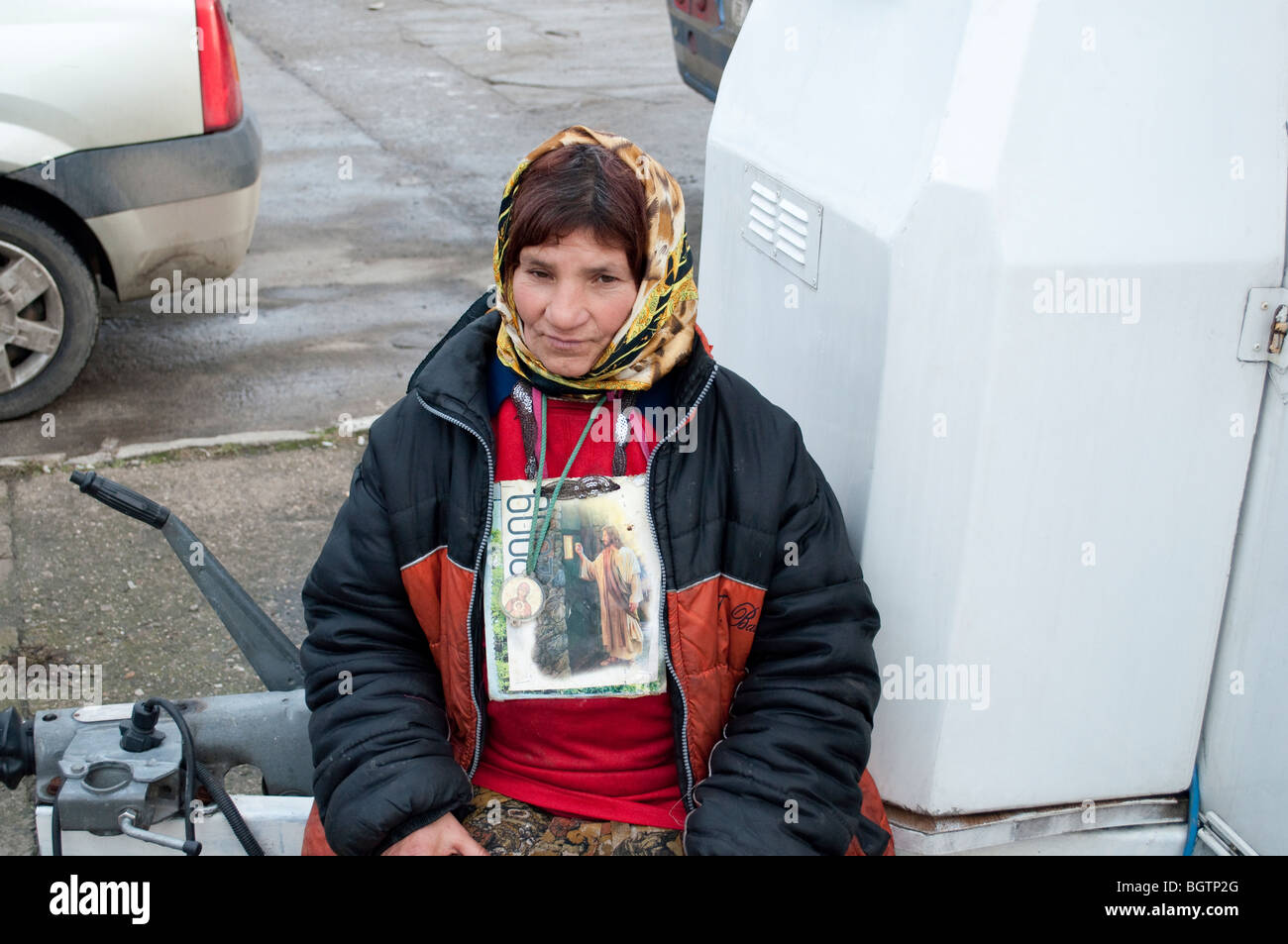 La persona senza dimora a mendicare con immagine di Gesù attorno al collo in Copsa Mica Romania Europa orientale Foto Stock