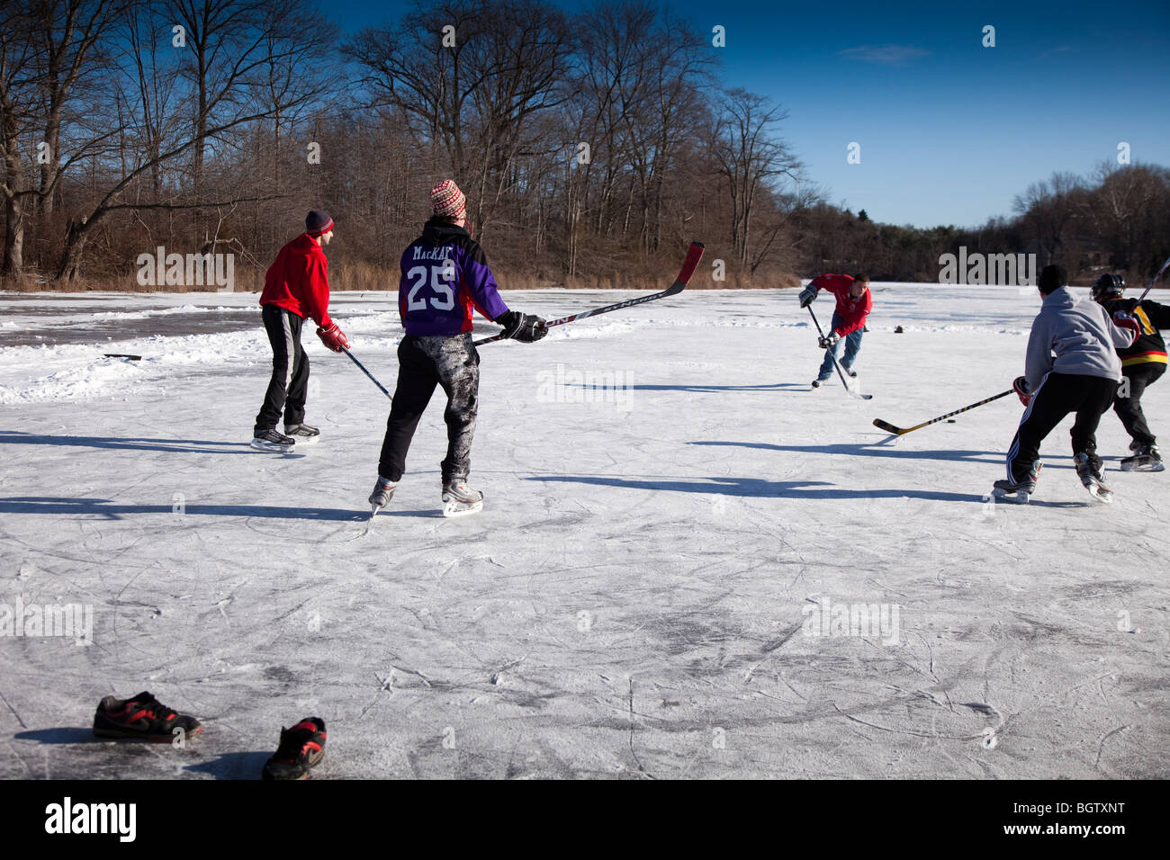 Riproduzione di hockey su ghiaccio su un laghetto congelato Foto Stock