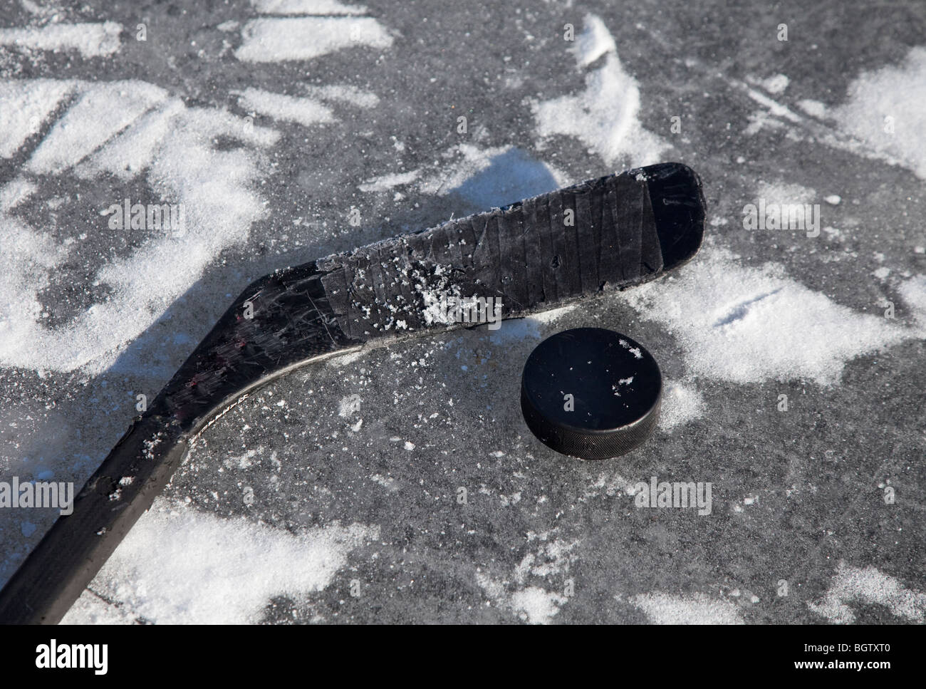 Mazza da hockey e puck su ghiaccio Foto Stock