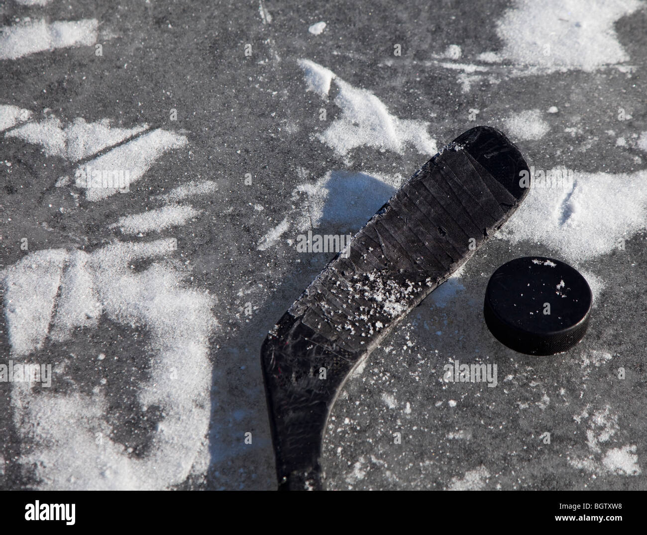 Ghiaccio hckey bastone e puck su ghiaccio congelato Foto Stock