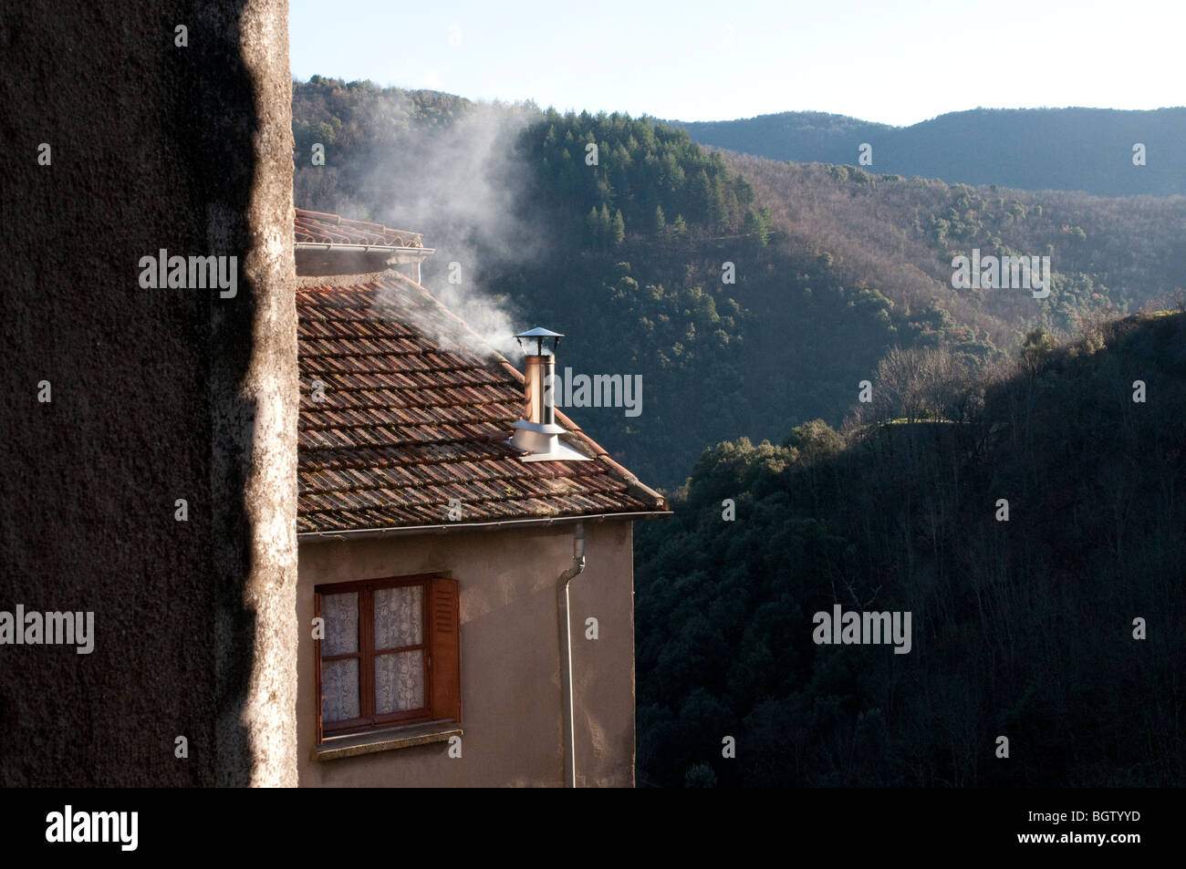 Fumo proveniente dal camino in una casa di San Marziale, borgo medievale nella valle Rieutord Gard, il sud della Francia Foto Stock