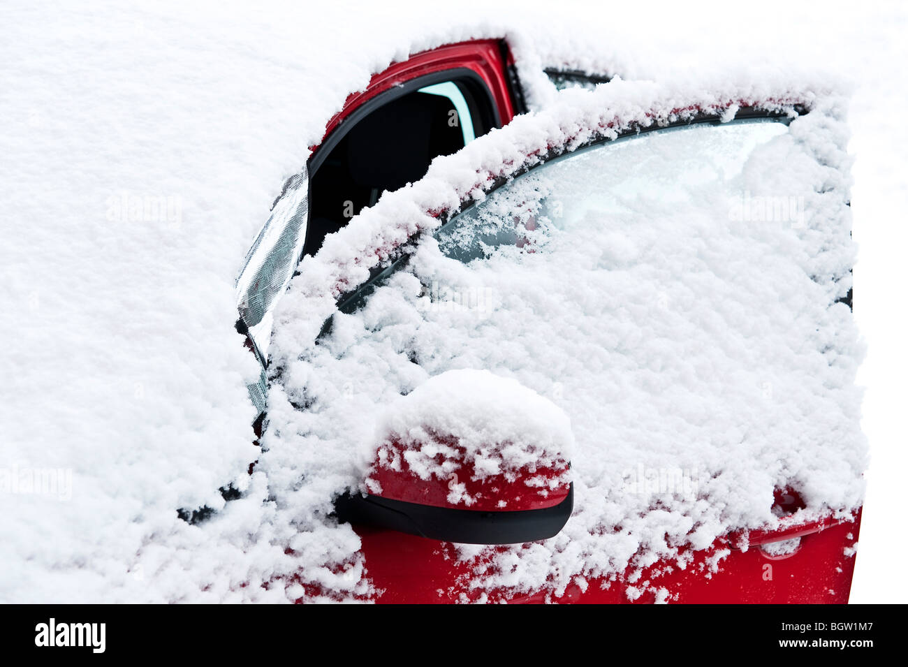 Auto rossa sotto un fresco strato di neve Foto Stock