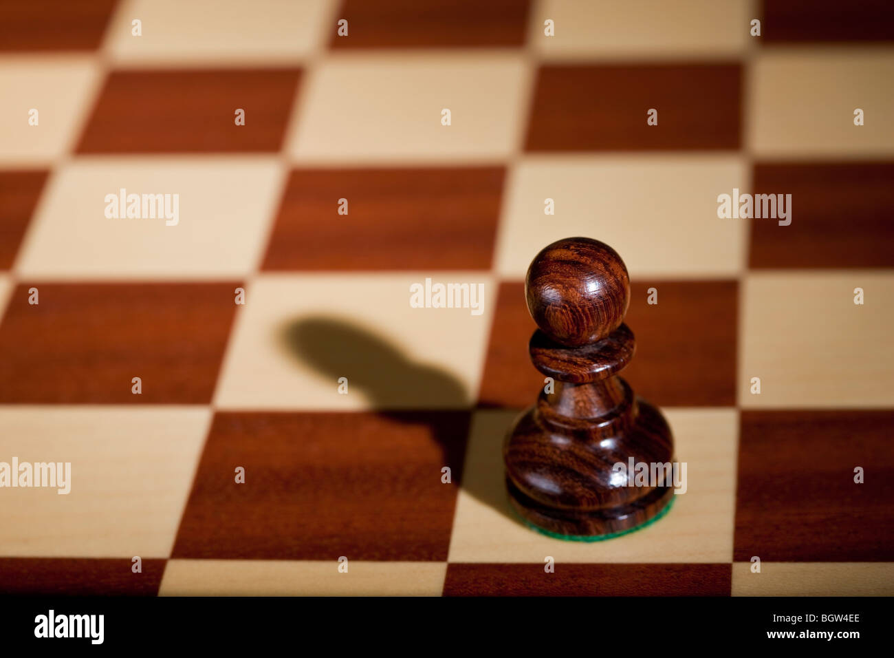 Pezzo degli scacchi - un pedone nero su una scacchiera. Foto Stock
