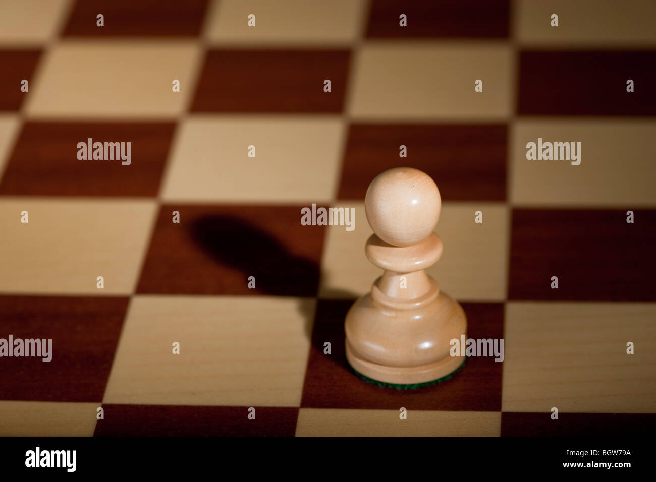 Pezzo degli scacchi - una pedina bianca su una scacchiera. Foto Stock