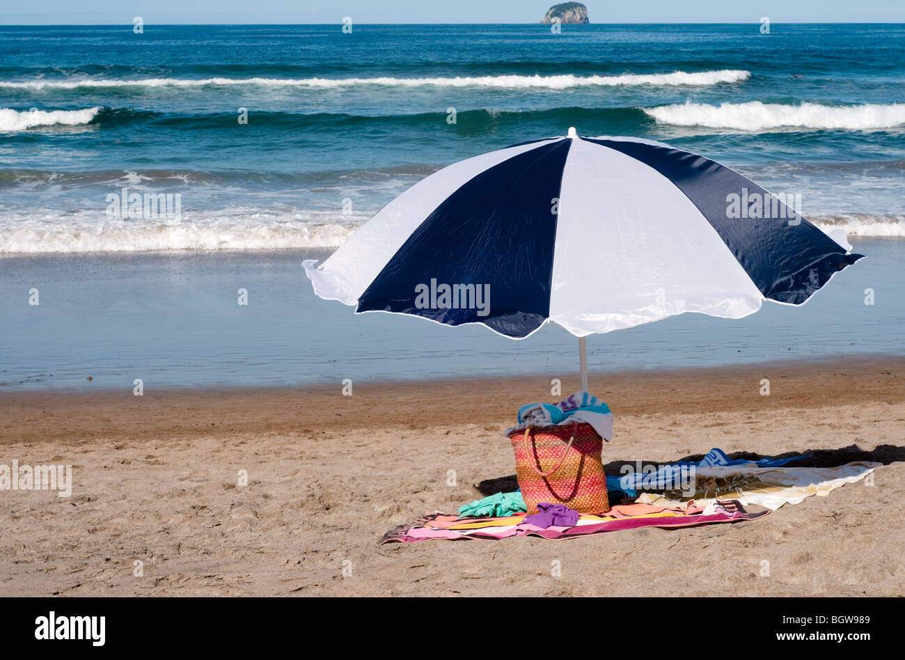 Borsa e ombrellone sulla spiaggia con asciugamani Foto Stock